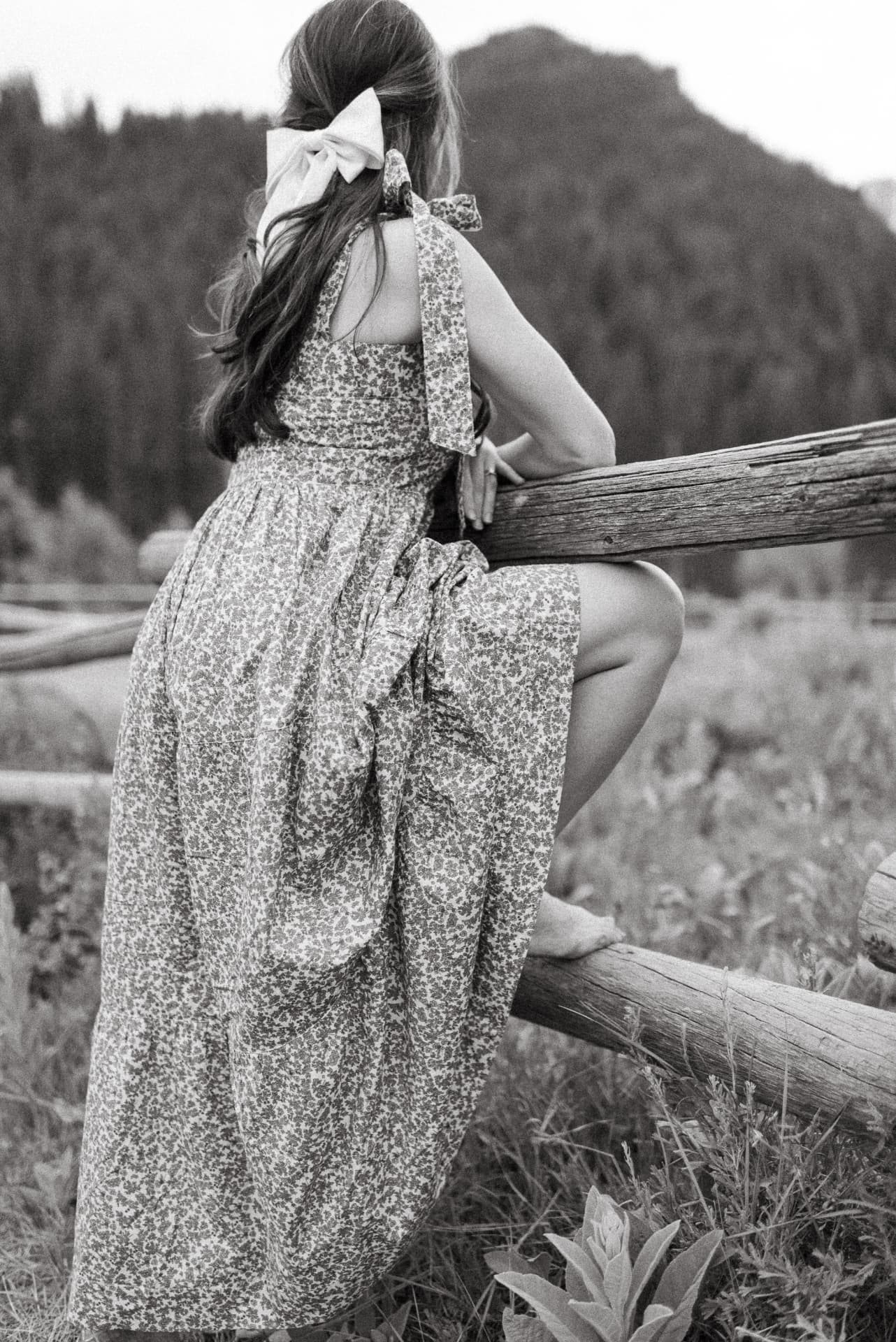 Floral tiered dress with a ribbon bow, photographed in black and white