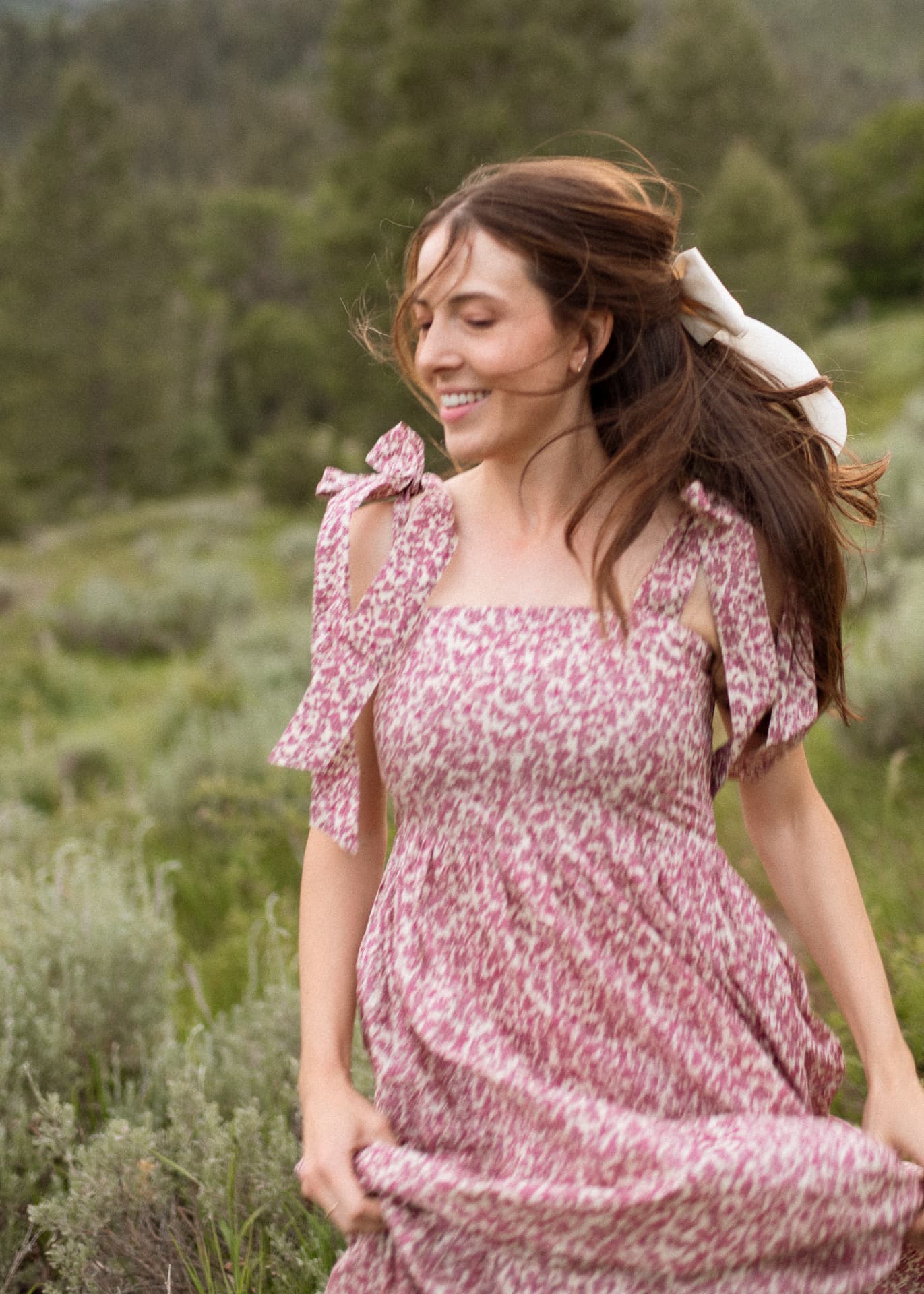 Woman in a rose floral tie-shoulder dress in a summer field